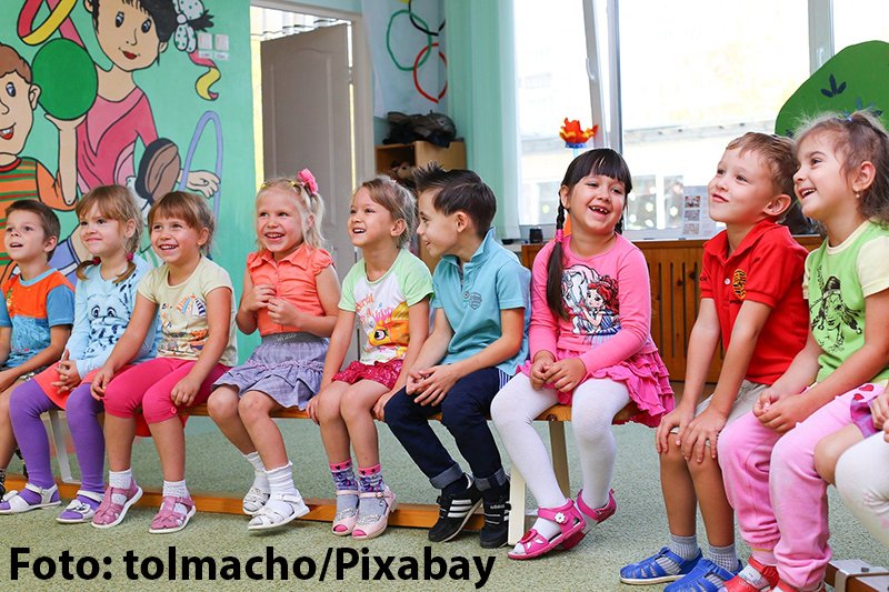 Gruppe von Kindern auf einer Bank im Kindergarten. 